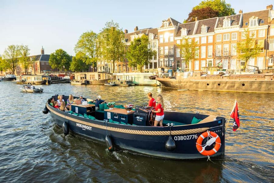 Amsterdam: Guided Open Boat Canal Cruise Including Drink - Comfort in open air: ponchos, umbrellas, and what to wear