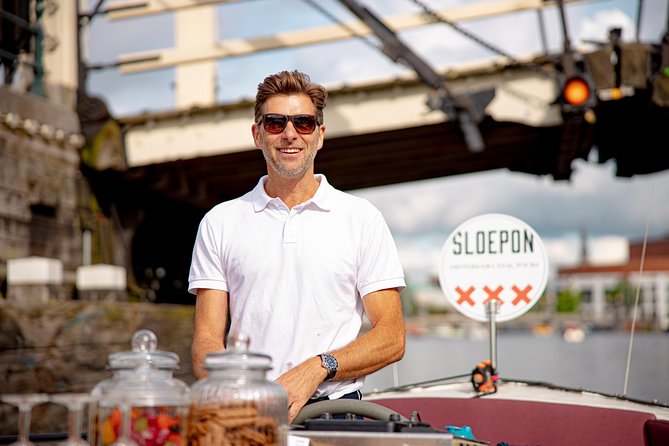 Guided Amsterdam Canal Cruise – Snacks & Drinks on board(1 Hour) - East India Company ship replicas and a futuristic ship-shaped skyline moment