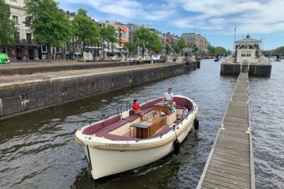 Guided Amsterdam Canal Cruise – Snacks & Drinks on board(1 Hour) - Amsterdam’s oldest waterways: leaning houses, narrow lanes, and a quiet 1306 church